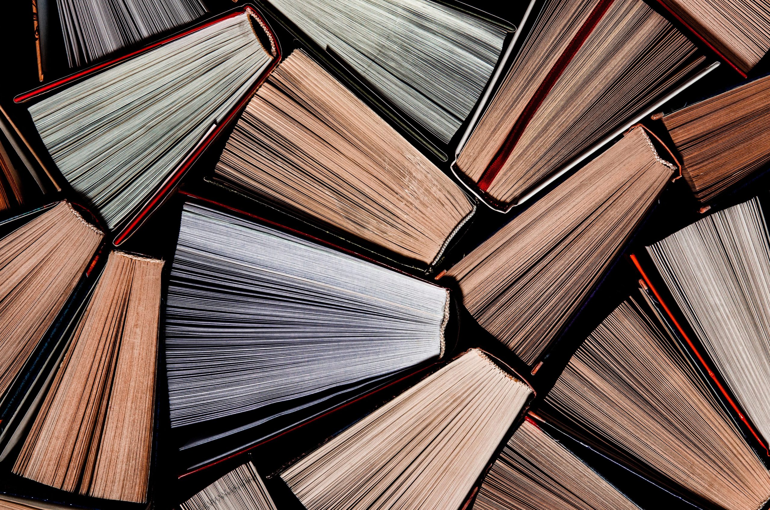 Books. Lots of colourful thick open books stand on a dark background. ready to read